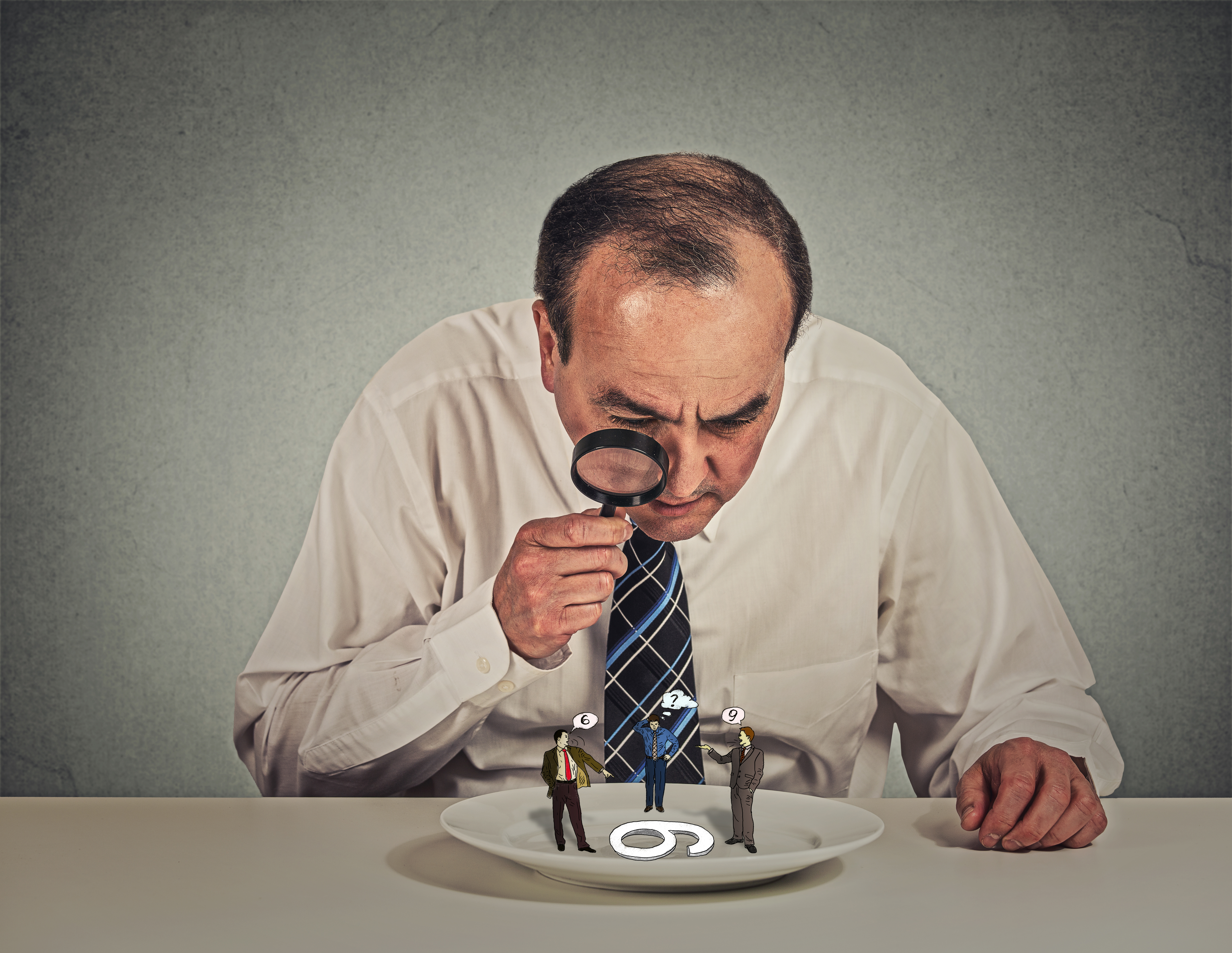 Curious corporate businessman skeptically meeting looking at small employee standing on table plate through magnifying glass